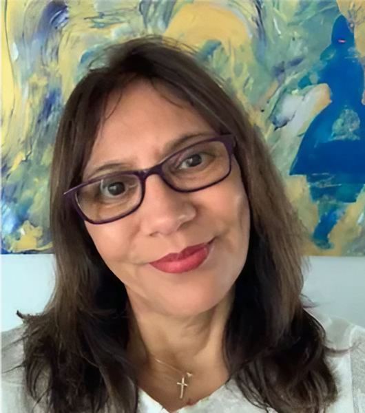 A woman with glasses and long hair wearing a white shirt.