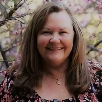 A woman with long hair and wearing a floral shirt.