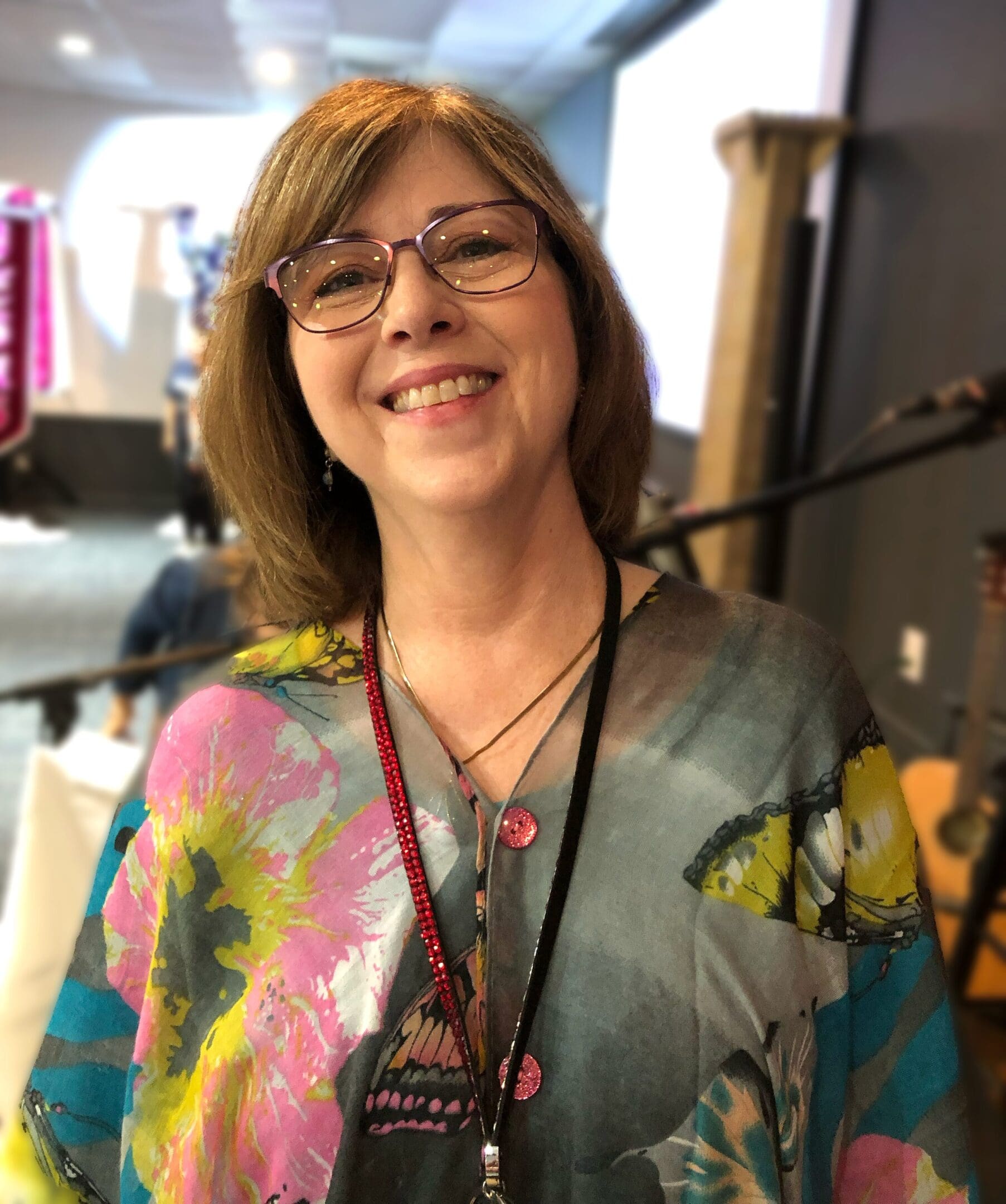 A woman with glasses and a colorful shirt.