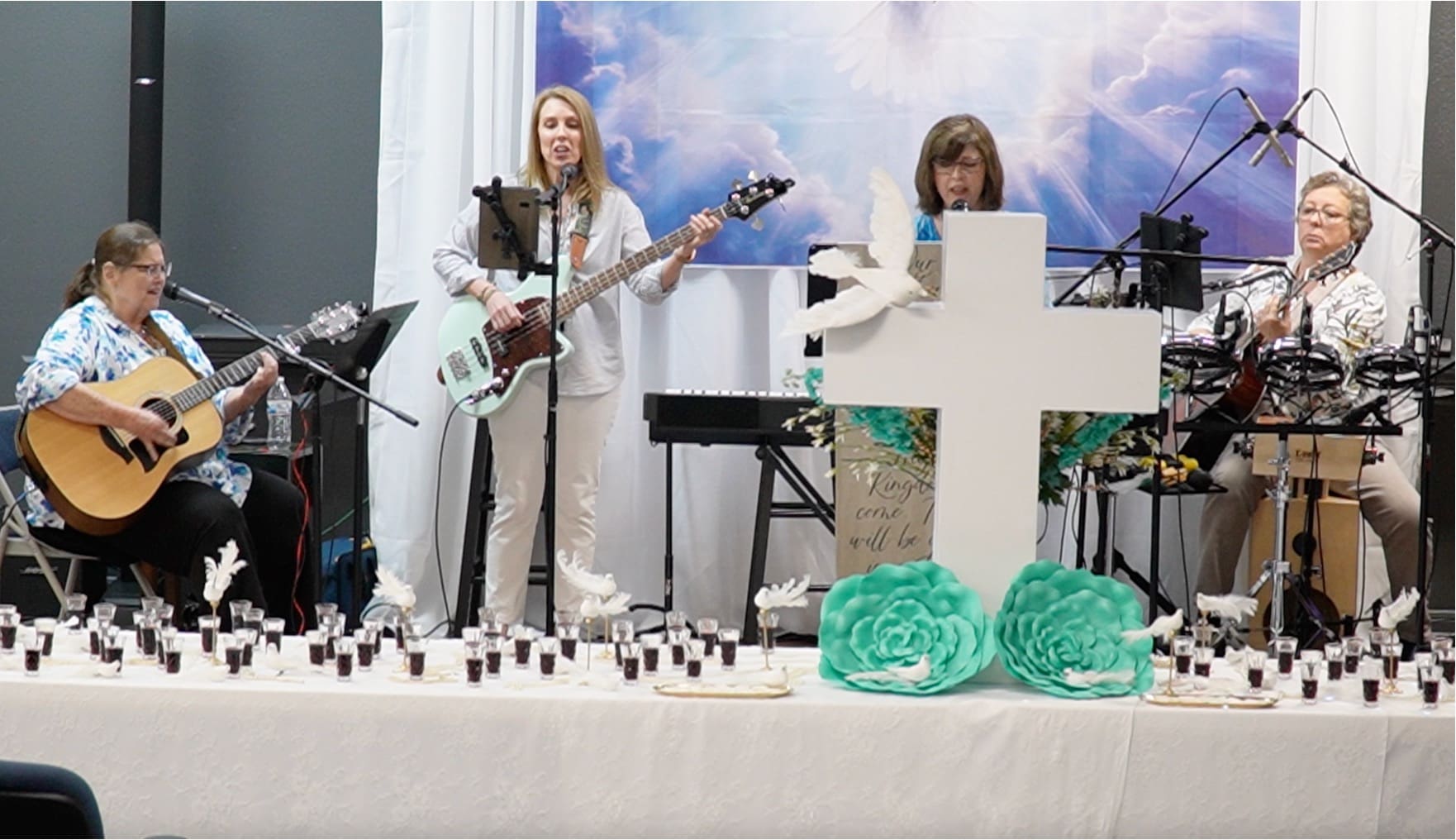 Two women are playing guitar and singing at a church.