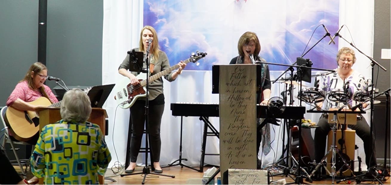 Two women are playing guitar and singing.