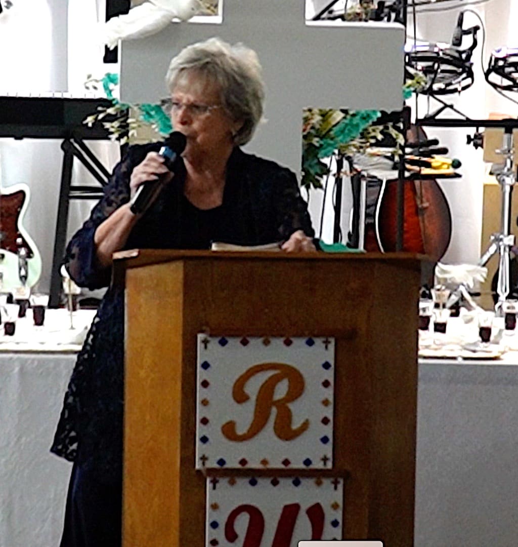 A woman is speaking at the podium of a business event.