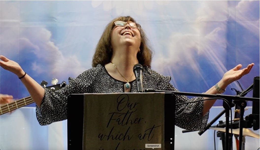 A woman standing at the top of a podium.