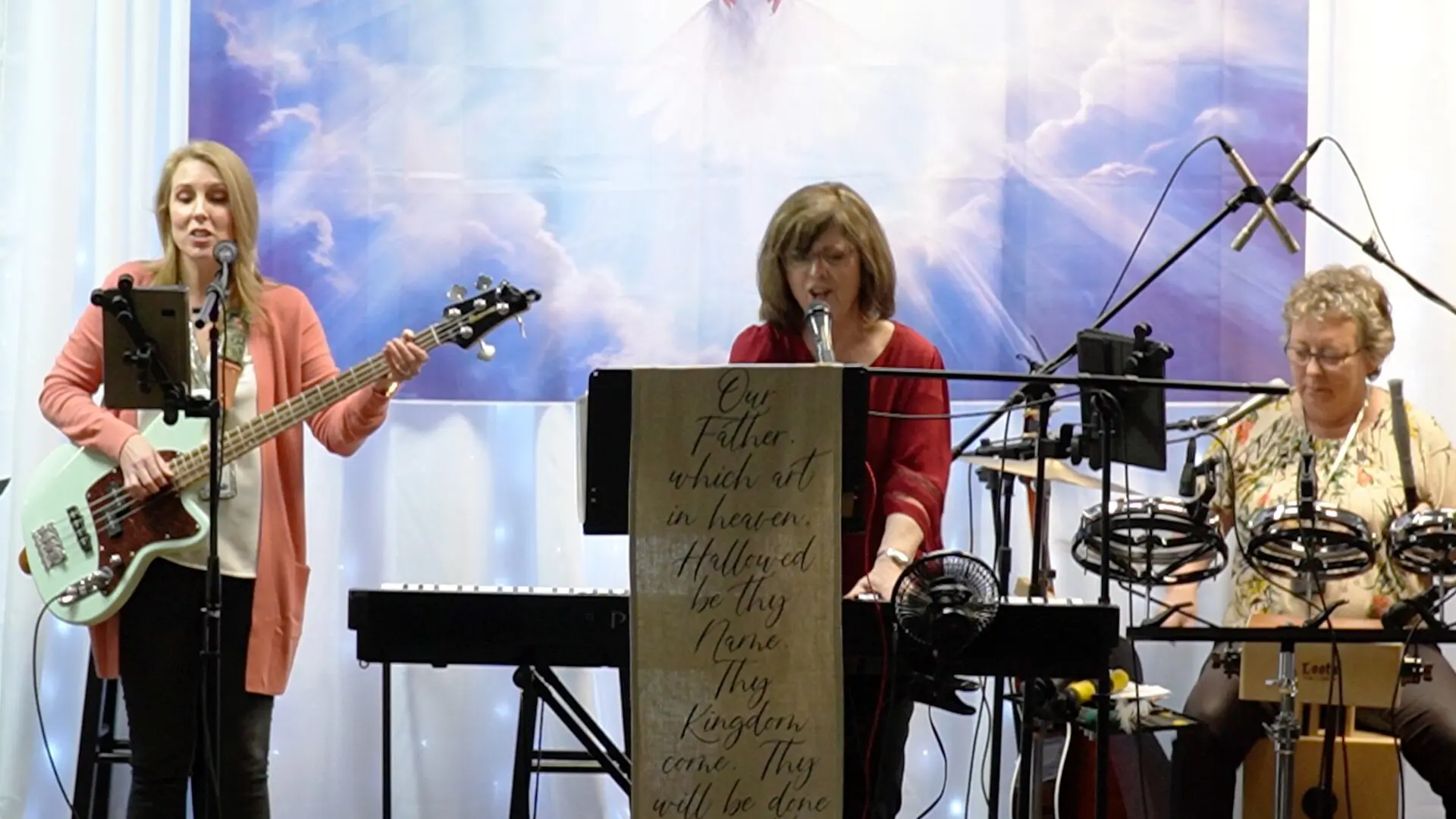 A woman is playing guitar and singing at the podium.