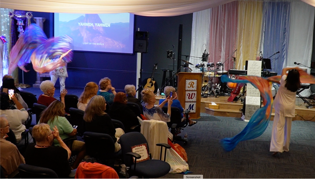 A group of people sitting in front of a projector screen.