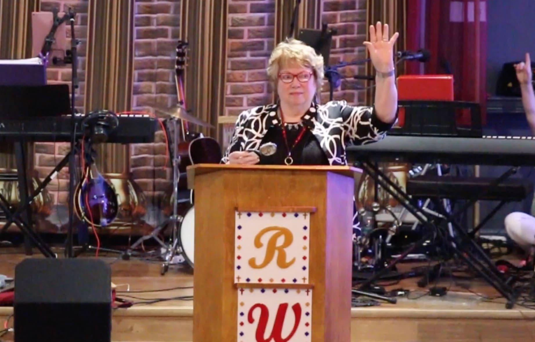 A woman is speaking at a podium in front of a microphone.