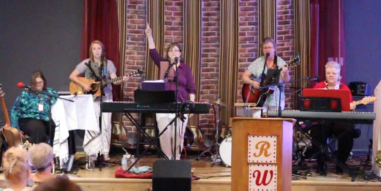 A group of people singing and playing instruments.