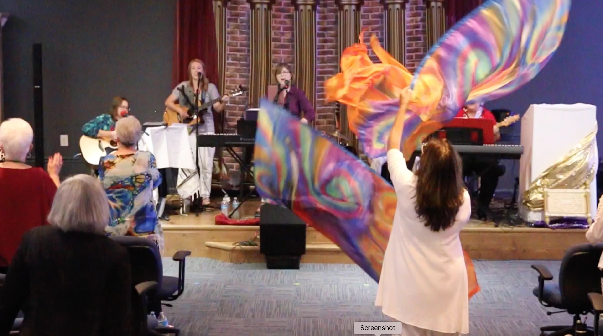 A woman holding up a colorful butterfly wing.