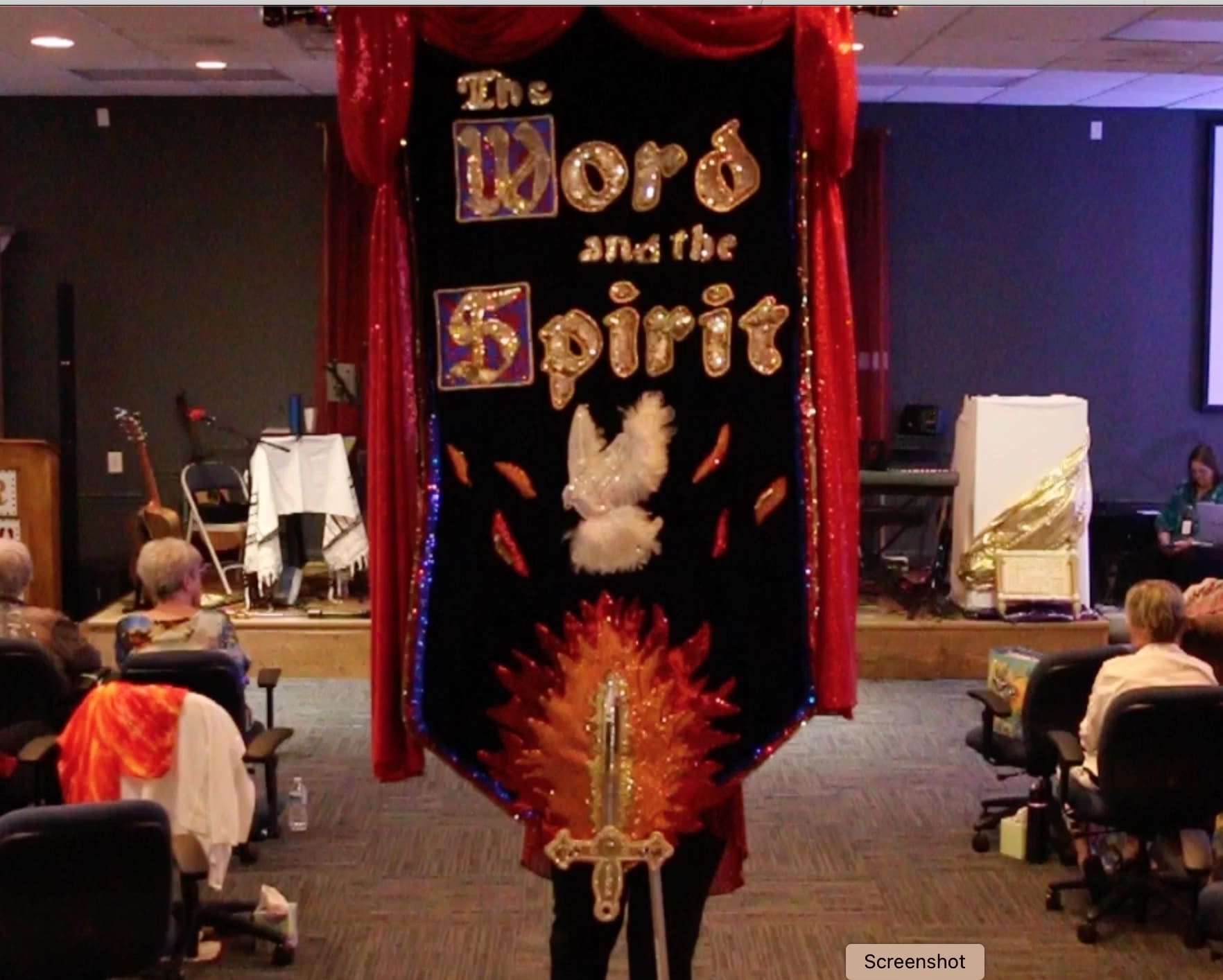 A woman standing in front of a banner with the words " the word and the spirit ".