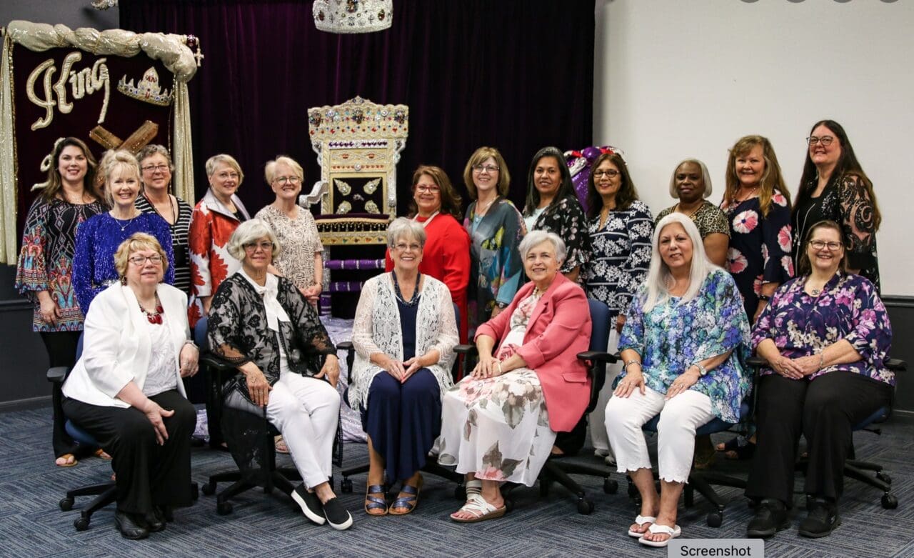 A group of women sitting in chairs posing for a picture.