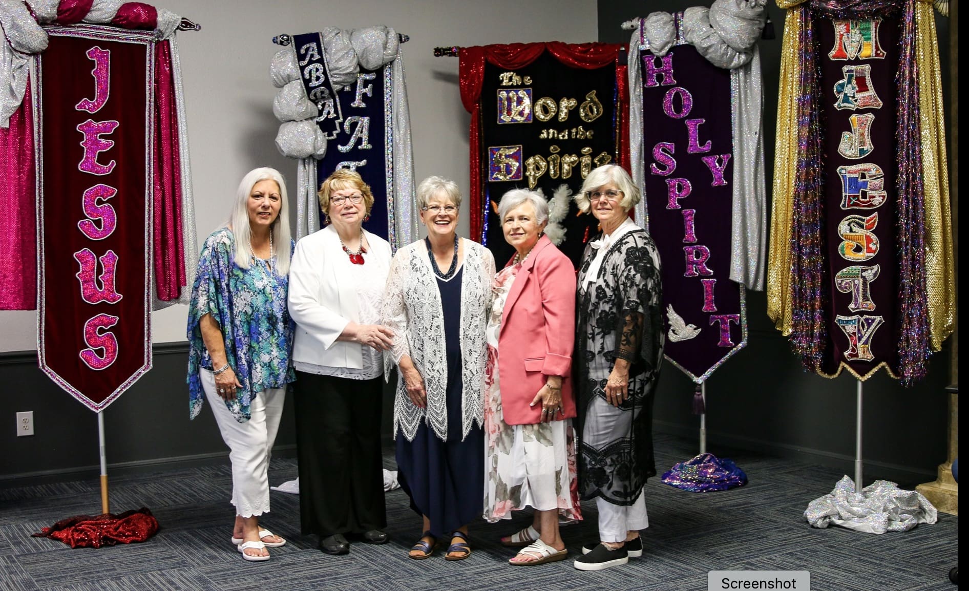 A group of women standing in front of a wall.