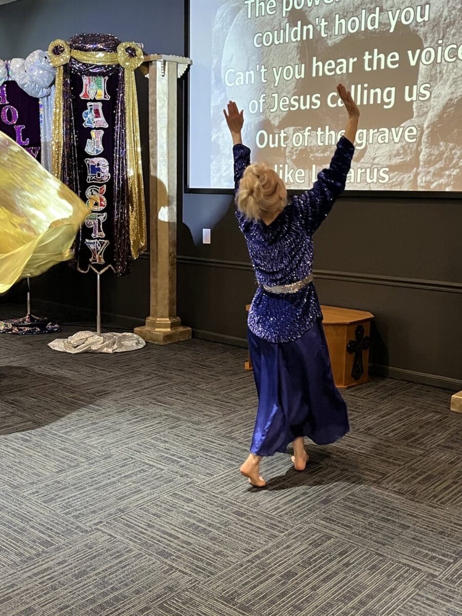 A woman in blue dress dancing on the floor.