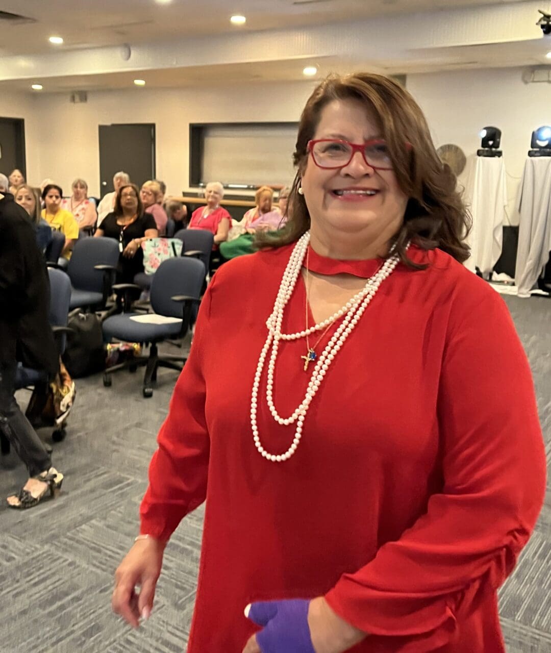 A woman in red is standing in front of a group.