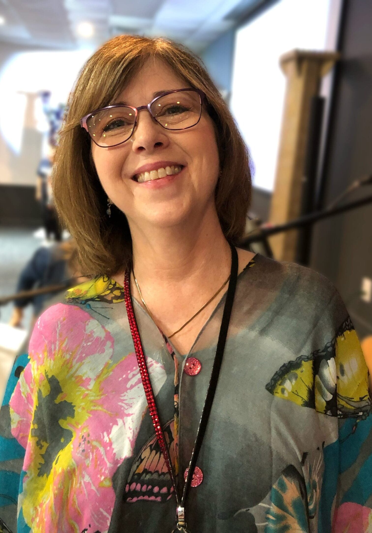 A woman with glasses and a colorful shirt.