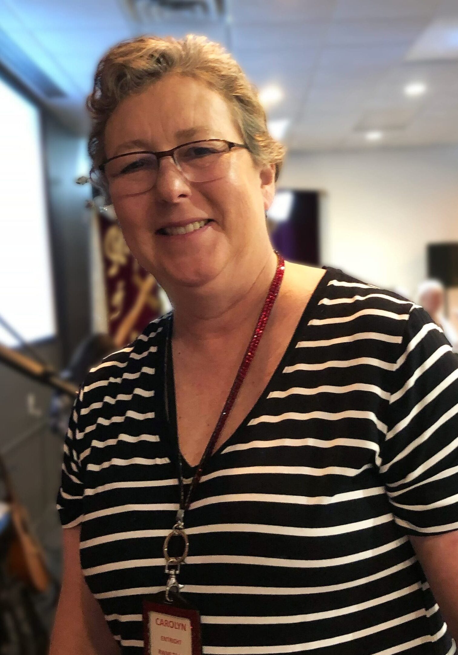 A woman with glasses and a striped shirt.