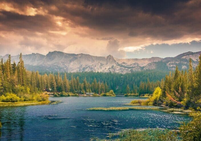 A river with mountains in the background under cloudy skies.