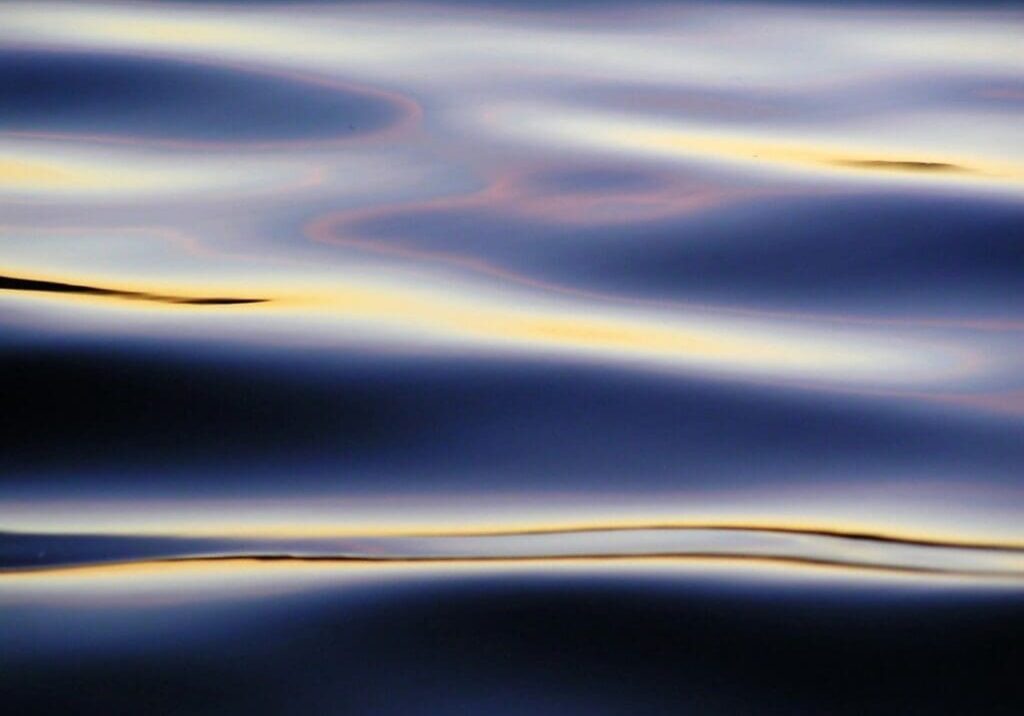 A blurry image of water and sky with gold lines.