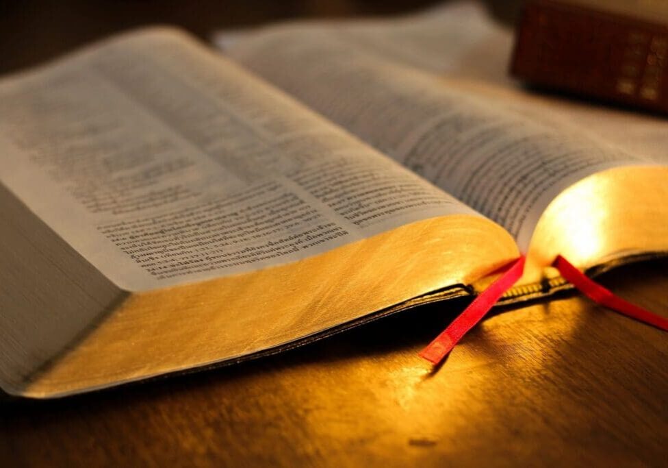 A lit candle is on top of an open book.