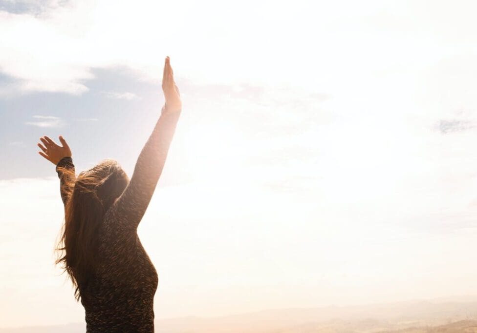 A woman with her arms raised in the air.