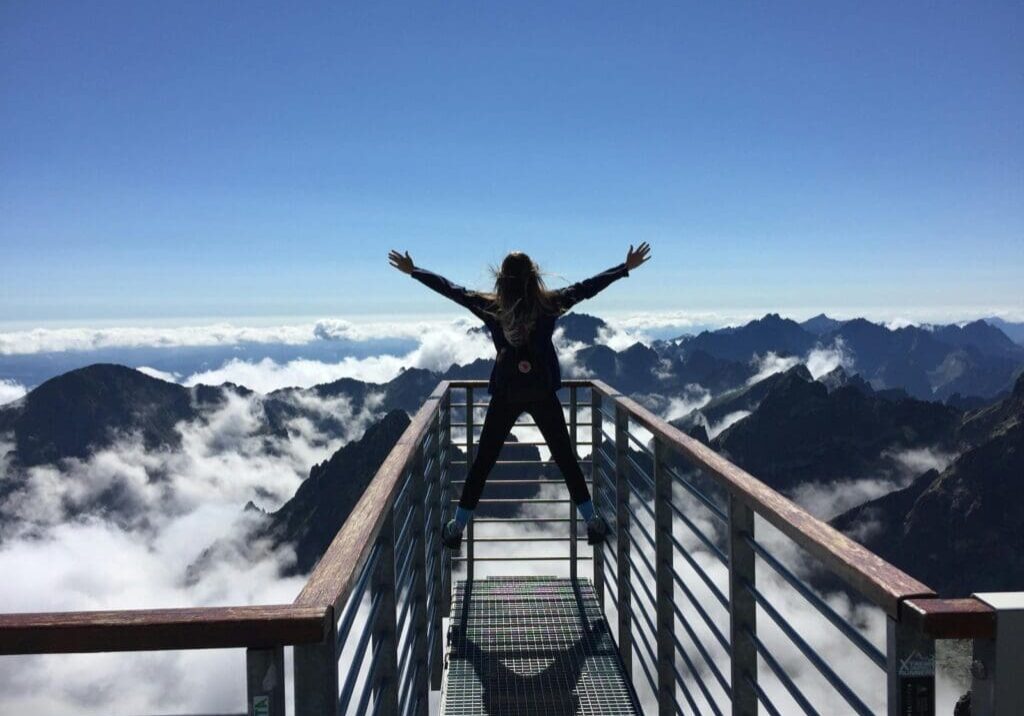 A woman standing on the top of a balcony.